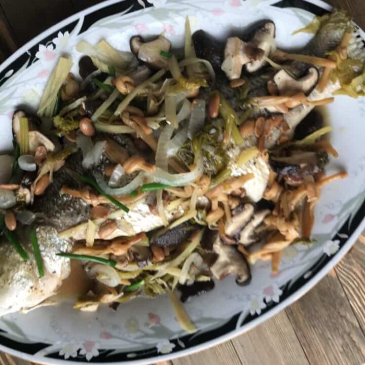 authentic vietnamese steamed whole fish with scallions, mushrooms, bamboo, onions